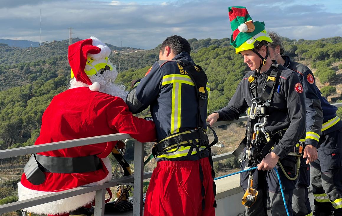 Los Bomberos Solidarios ayudan a Papá Noel en el tejado de Can Ruti