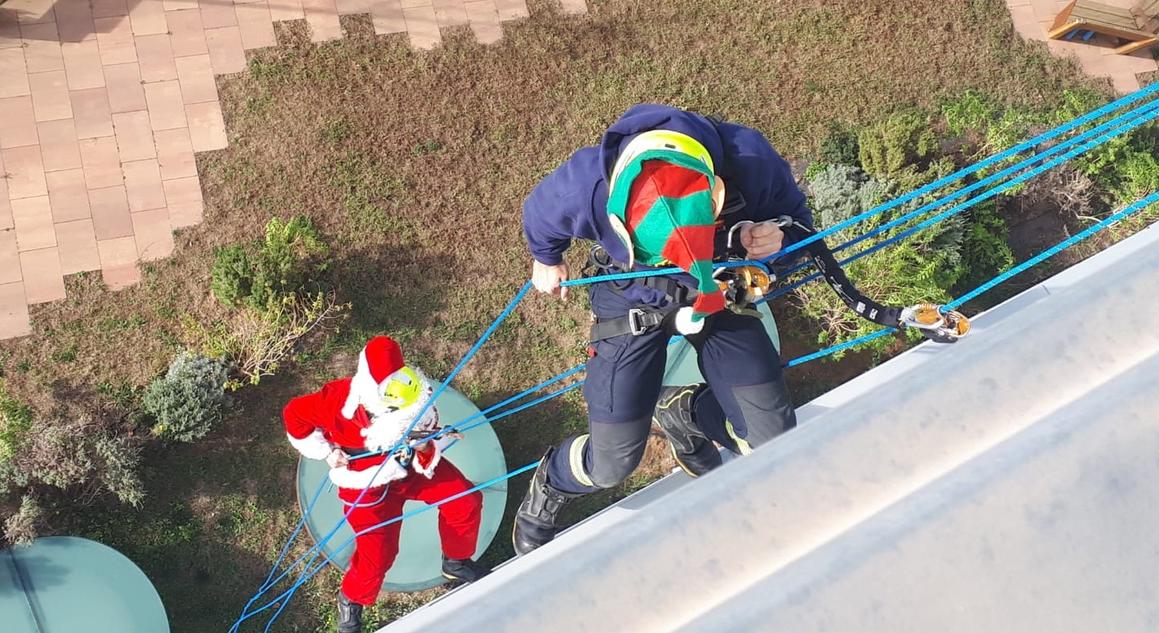 Papá Noel y un ayudante bajan por la fachada de Sant Pau